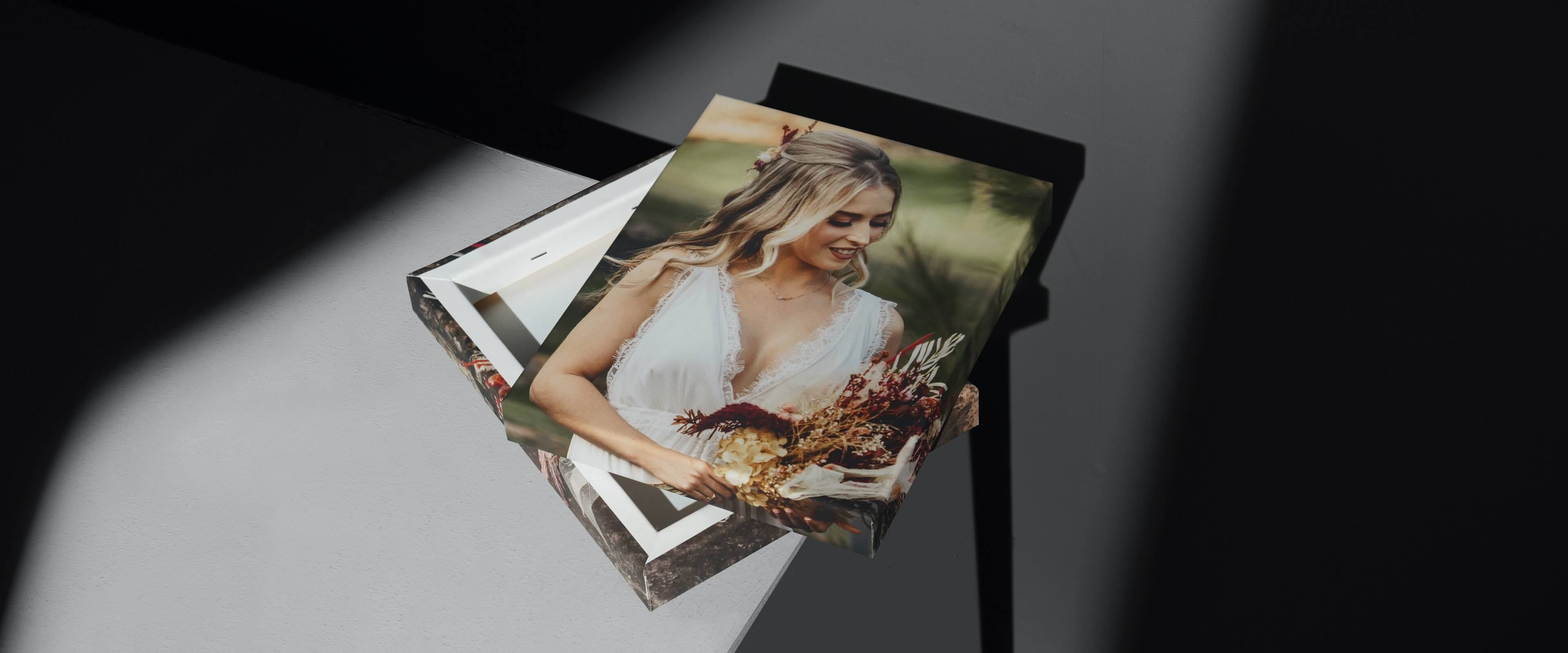 canvas gallery wraps on white table with photo of lady in white dress holding flowers